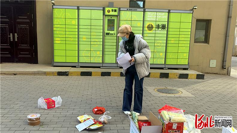 1月30日，石家庄桥西区盛世御城小区居民正在社区团购提货点寻找自己的商品。 河北日报记者赵泽众摄