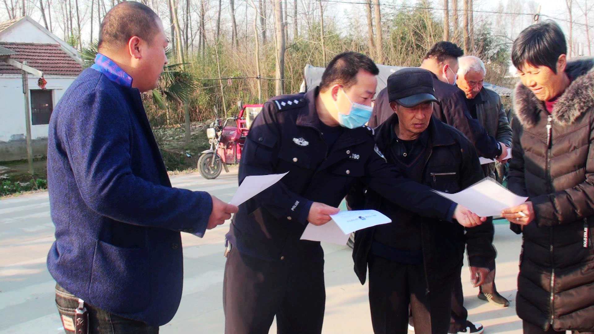 彭塔派出所副所长李永正（左二）在该镇隐贤初中门前散发“防电信诈骗”宣传单