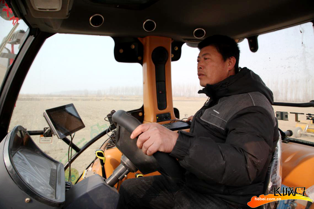 芦台经济开发区嘉氏兴农机专业合作社农机手正在驾驶拖拉机平整土地.