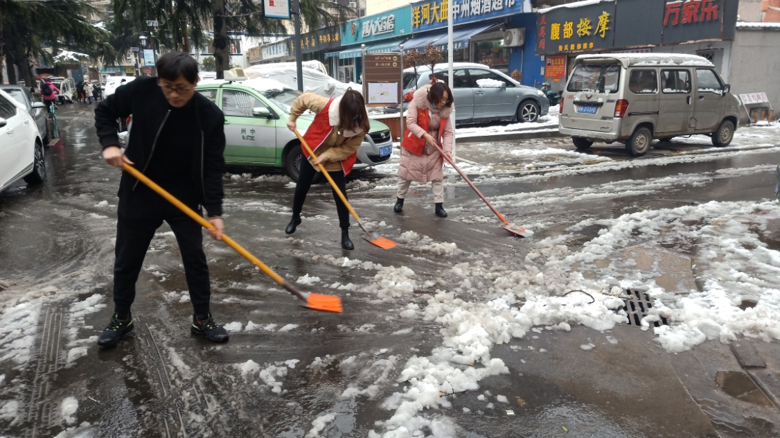 社区工作人员、志愿者一起清扫积雪