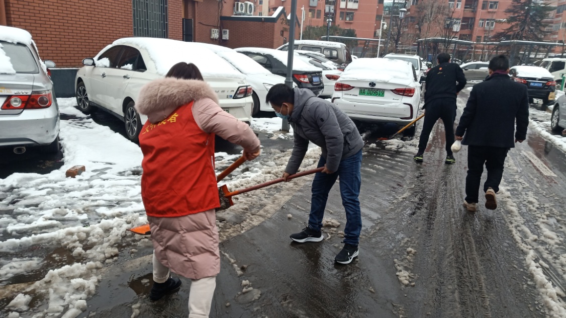 社区工作人员、志愿者、居民一起清扫积雪