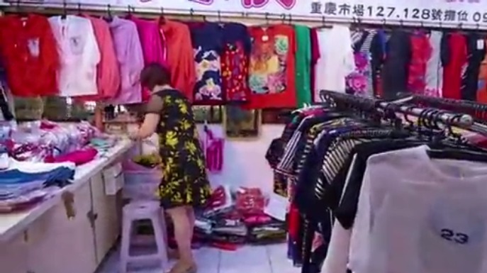 服装店老板在台湾菜市场内开店，买菜的女顾客在这里挑选心仪的服装