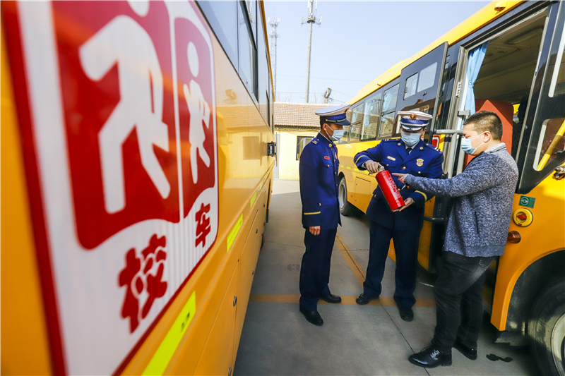 2月20日，河北唐山遵化市消防救援大队的消防救援人员在检查校车灭火器。