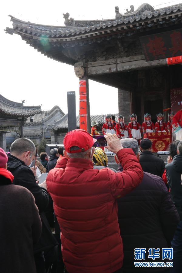 戏台前，游人拿出手机拍照留念。新华网 发