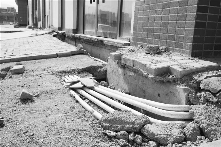 商铺地基下沉，大量管线裸露在外。掌上兰州&middot;兰州晨报记者 赵鑫远 摄