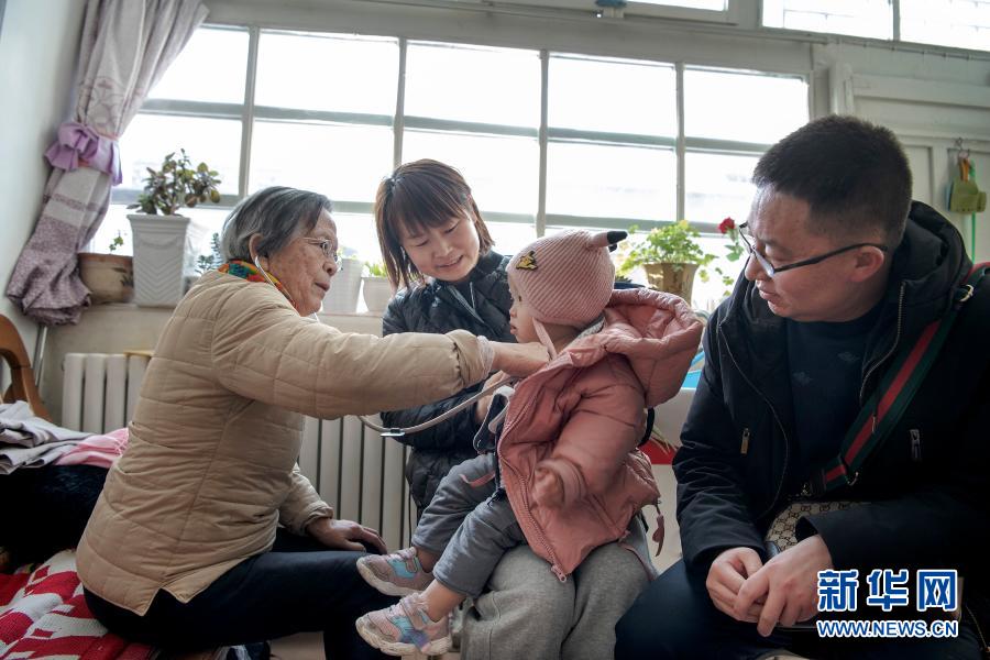路生梅（左一）在佳县家中为患儿义诊（1月16日摄）。新华社记者 陶明 摄