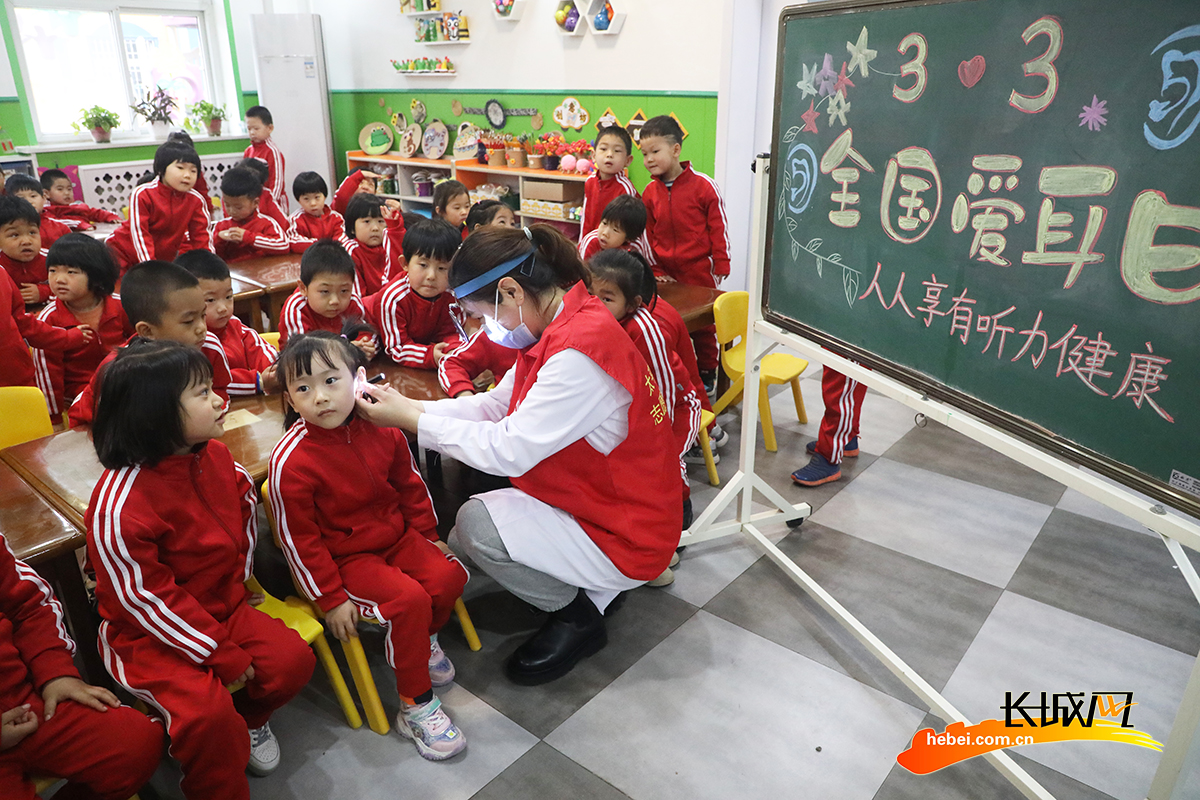 3月3日，在丰润区光华道幼儿园，医生志愿者为小朋友进行耳道检测。朱大勇 摄