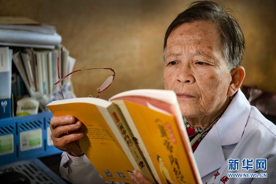 在佳县中医院门诊义诊的路生梅，没有病人时坚持看书学习（2020年4月8日摄）。新华社记者 陶明 摄
