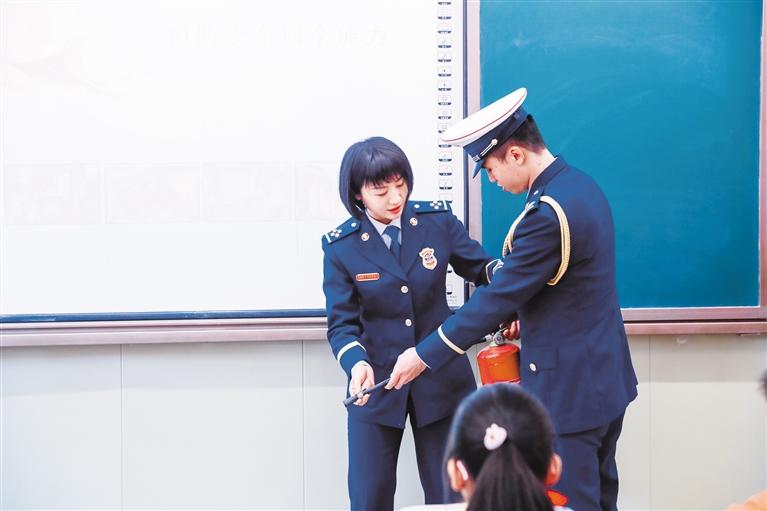 支队宣传人员向同学们讲解灭火器的正确使用方法 掌上兰州&middot;兰州晨报记者 姚智 摄