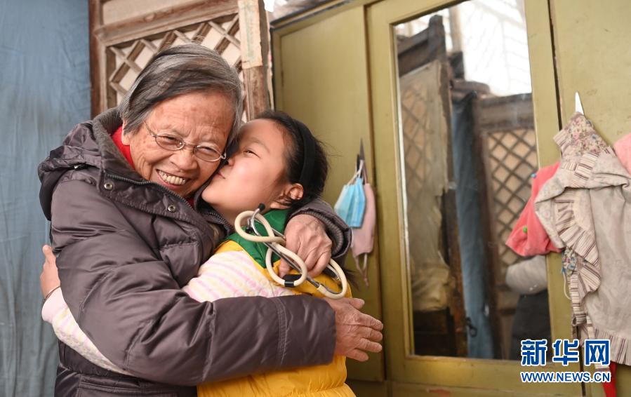 路生梅（左）在佳县佳州街道凌云社区义诊时，8岁的张宇旋与她告别时拥抱（1月17日摄）。张宇㫌一家祖孙三代都曾让路生梅看过病。新华社记者 陶明 摄