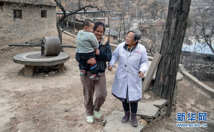 路生梅（右）在佳县店镇贺家沟村义诊途中，向一名家长了解孩子情况（1月15日摄）。新华社记者 陶明 摄