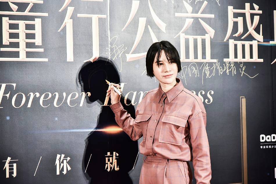 电子唱作人尚雯婕在2018年凤凰网“美丽童行”公益盛典红毯区签名