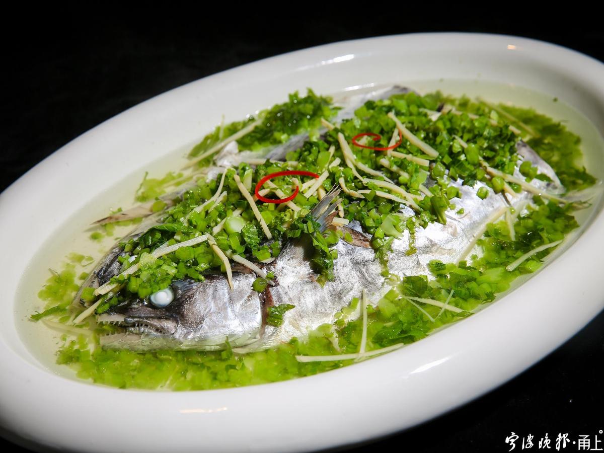 同样一盘咸菜烧马鲛鱼，宁海食府的大厨童海波掌勺，就烧出了新花样，用青咸菜烧煮，色泽鲜亮，口味更为清爽鲜美。