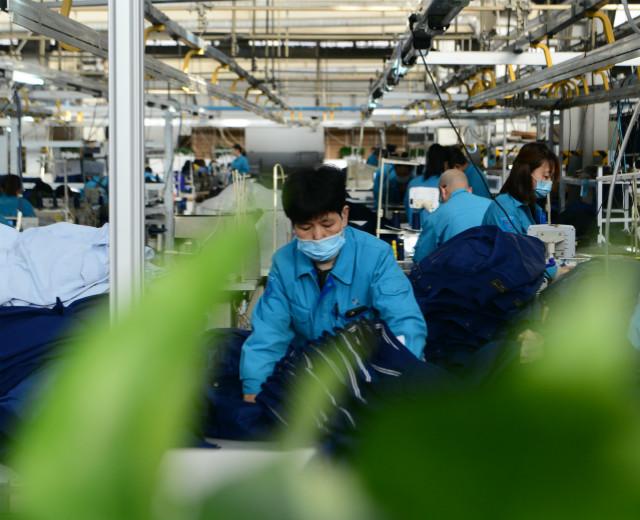 2021年2月5日，在井陉县际华三五零二职业装有限公司，工人在服装车间生产线上工作。新华社图。