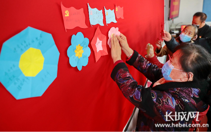 社区党员将写有"心里话"的彩色纸贴到党旗墙上.曹建雄 摄