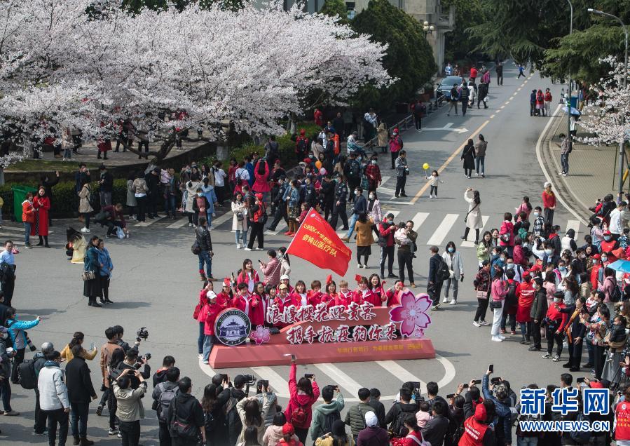 3月13日，辽宁援鄂医疗队员在武汉大学樱花树下合影。新华社记者 肖艺九 摄
