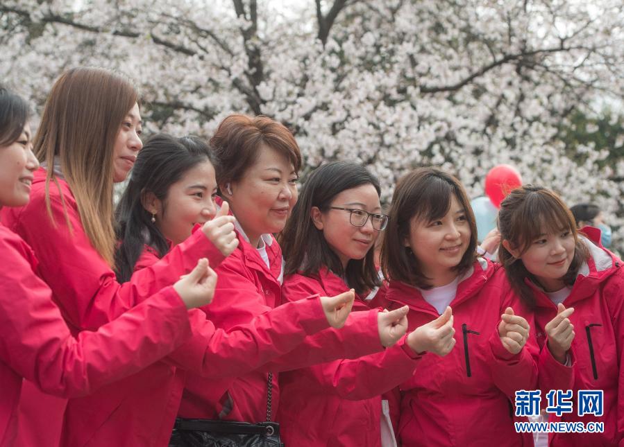 3月13日，上海第四批中医医疗队龙华医院医护人员在武汉大学樱花树下合影。新华社记者 肖艺九 摄