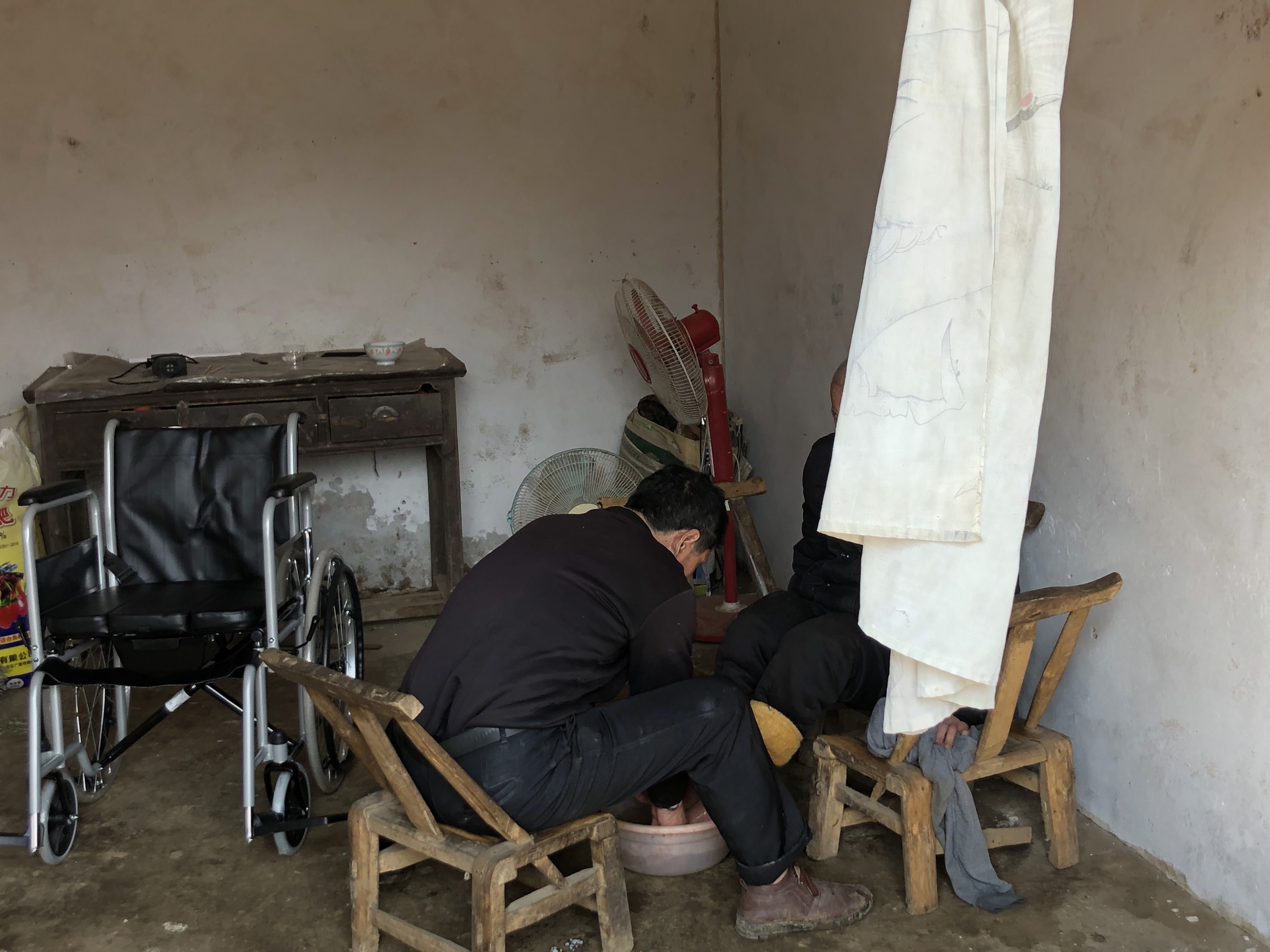 张新照在给87岁的父亲洗脚。新京报记者 杜寒三 摄