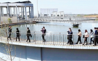 江夏污水处理厂厂长刘赛（左一）介绍4号沉池污水污泥处理工艺流程。