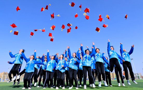 3月21日，甘肃张掖中学的学子们在成人礼上把“成人帽”抛向空中。当日，张掖中学为年满18岁的高中生举行成人礼。王将/视觉中国