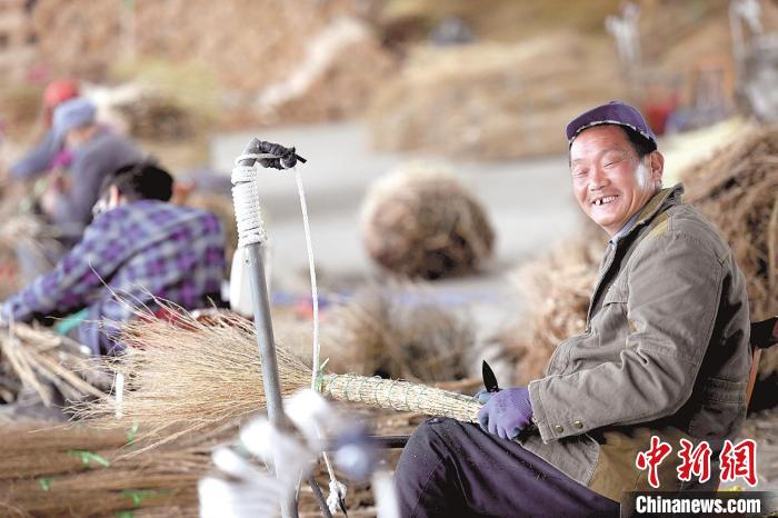 55岁村民文廷山在恒达扫帚专业合作社编织扫帚(资料图) 田悦 摄