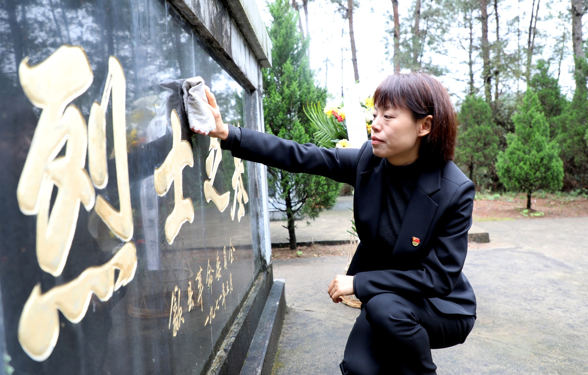 歙縣退役軍人事務局黨員汪嵐在大山公墓烈士陵園,擦洗烈士陵墓.