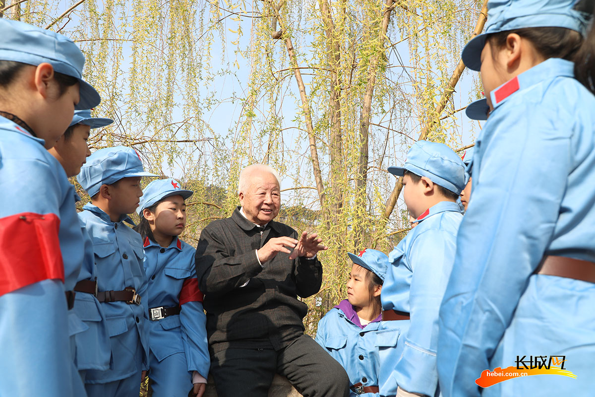 在唐山市丰润区山缘生态庄园景区，抗日烈士后代、83岁的王辅睿老人向小学生讲述冀东抗战史。