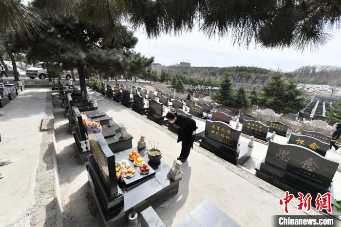 刘利芳代替无法亲赴现场祭拜的客户进行擦墓碑、鞠躬、献花等祭扫仪式并通过手机向客户展示是她的工作之一。　张瑶 摄