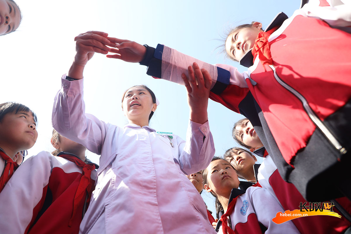 唐山市丰润区姜家营乡杨家铺小学，医护人员向学生传授急救包扎技巧。