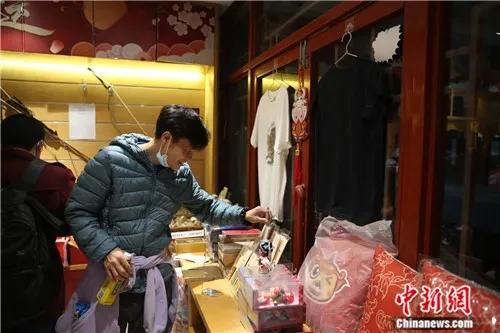 4月2日晚，一位顾客在潘家园文创商店内挑选商品。<a target='_blank' href='http://www.chinanews.com/'>中新社</a>易海菲 摄