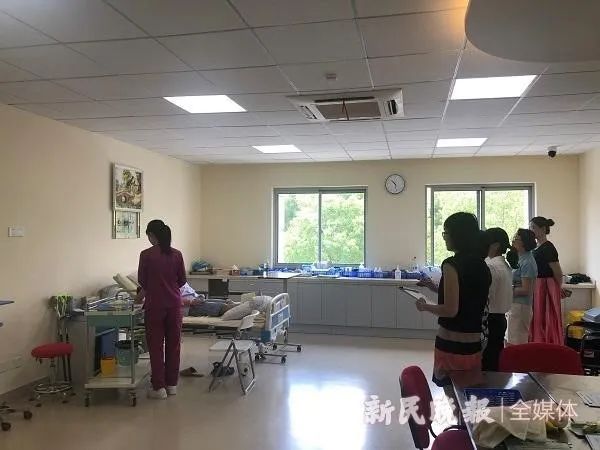 (杨梦菁娴熟地为病人做检查和护理,图源新民晚报)