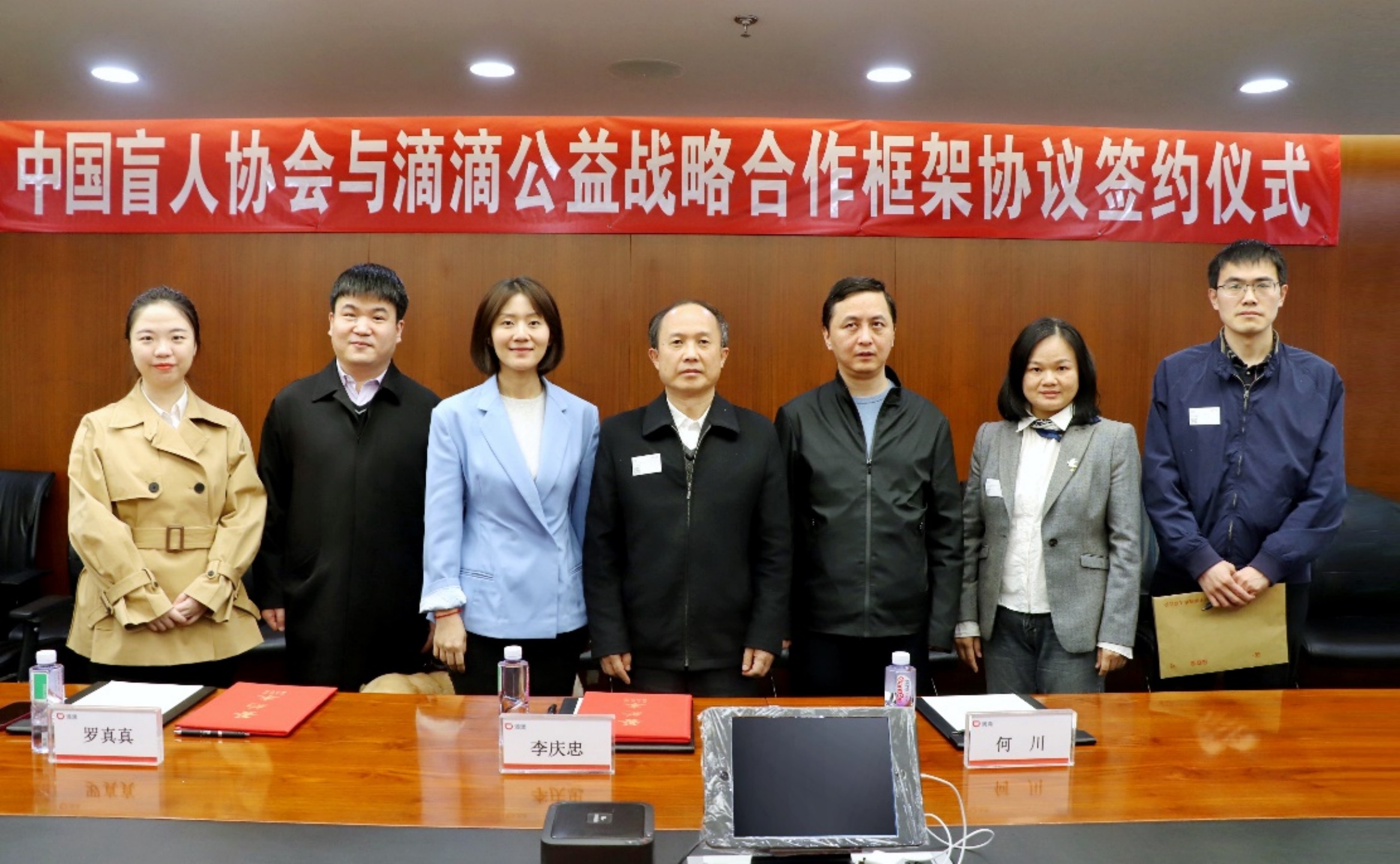 中国盲人协会主席李庆忠(左四)与滴滴企业社会责任负责人罗真真(左三)现场签订战略协议