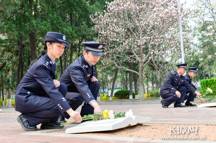 民警向革命烈士墓碑敬献鲜花。
