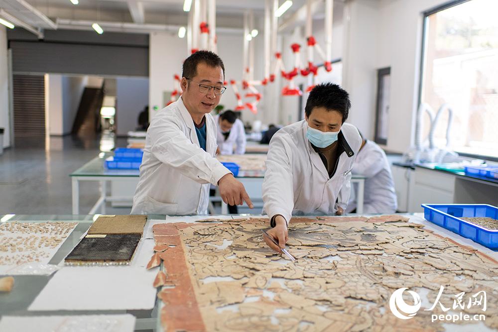 戴宇翔正在与刘洪斌老师一起拼接墓葬壁画。人民网记者 翁奇羽摄