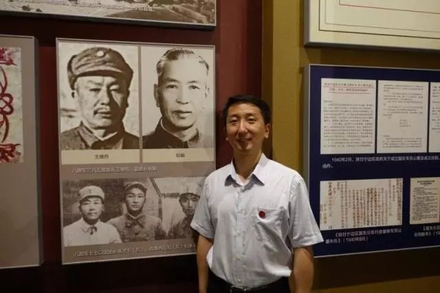 （2015年，耿巍在庆阳南梁革命纪念馆有关爷爷的展板前留影。）
