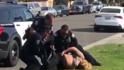 美国警察将女嫌犯按在地上猛打头部，两名同伴立即制止