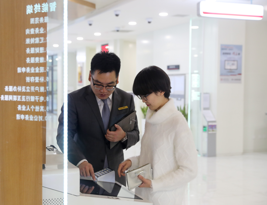 一银行网点工作人员在协助客户办理Ⅱ类账户银行卡。新华社发