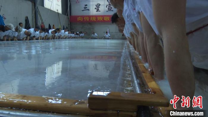 捞纸师傅们将巨型的纸帘放入纸槽中进行捞制。 刘鸿鹤 摄