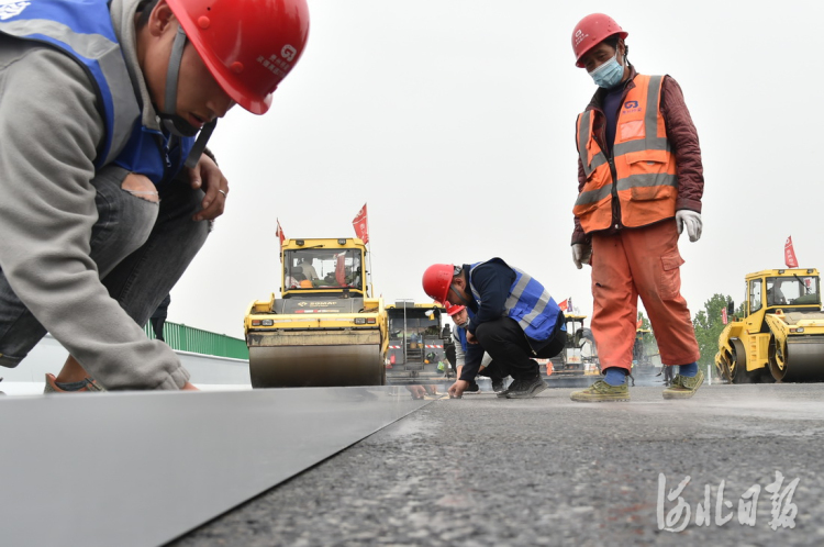 2021年4月21日,京德高速公路一期工程“永久路面”摊铺现场,工作人员认真测量路面平整度。 河北日报记者赵海江摄