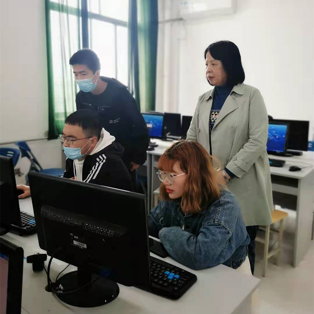 刘淑颖教授(右一)观看学生现场操作演示无纸化考试系统