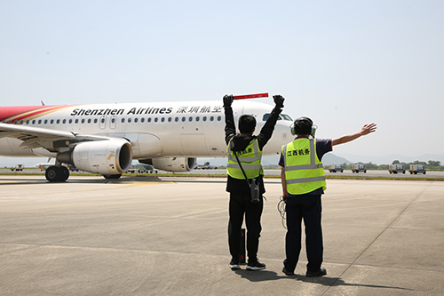 机务工作人员指挥飞机入位