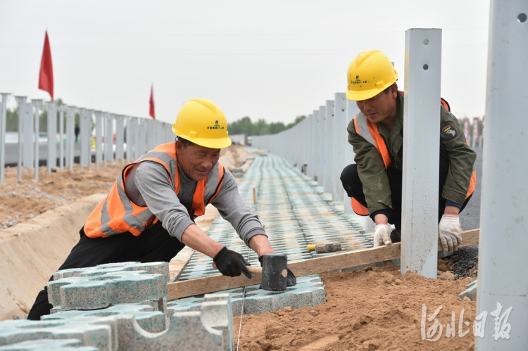 2021年4月21日,工人正在京德高速公路铺设隔离带地砖。 河北日报记者赵海江摄
