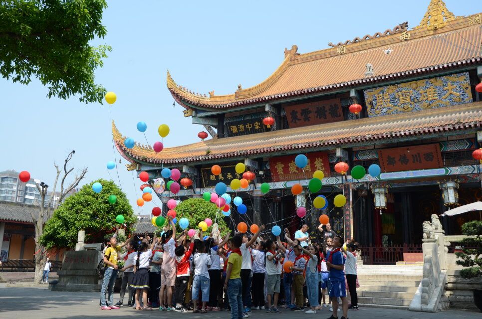 2018年，十周岁集体生日会上，手持气球的“罗汉娃”聚在大雄宝殿门口。受访者供图