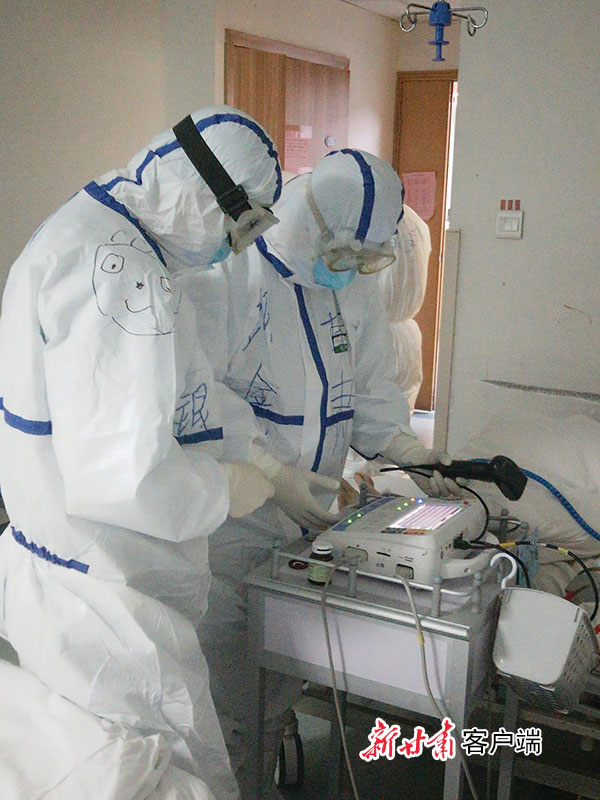 杨银功（左一）在隔离病房给患者做心电图
