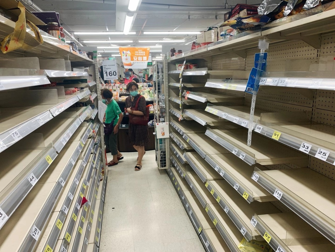 疫情之下,台北市民外出抢购防疫物资,超市内泡面等即食产品抢购一空.