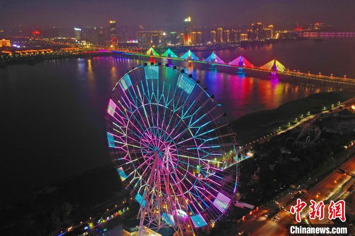 矗立在南昌市红谷滩区赣江之畔的“南昌之星”摩天轮亮起绚丽的灯光，与远处五彩缤纷的朝阳大桥交相辉映。　刘占昆 摄