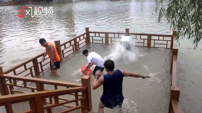 暴雨后高校湖水水位上涨，学生排队涉水，打水仗撒欢