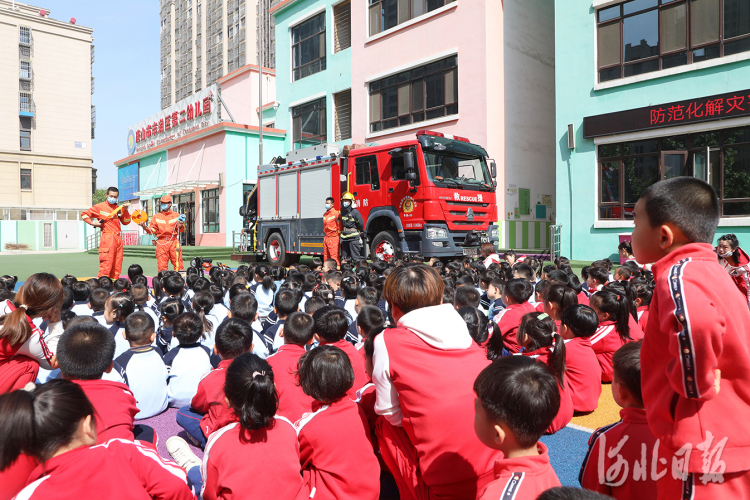 2021年5月11日,在河北省唐山市丰润区第二幼儿园,消防员为小朋友介绍消防装备的使用方法。通讯员朱大勇摄影报道