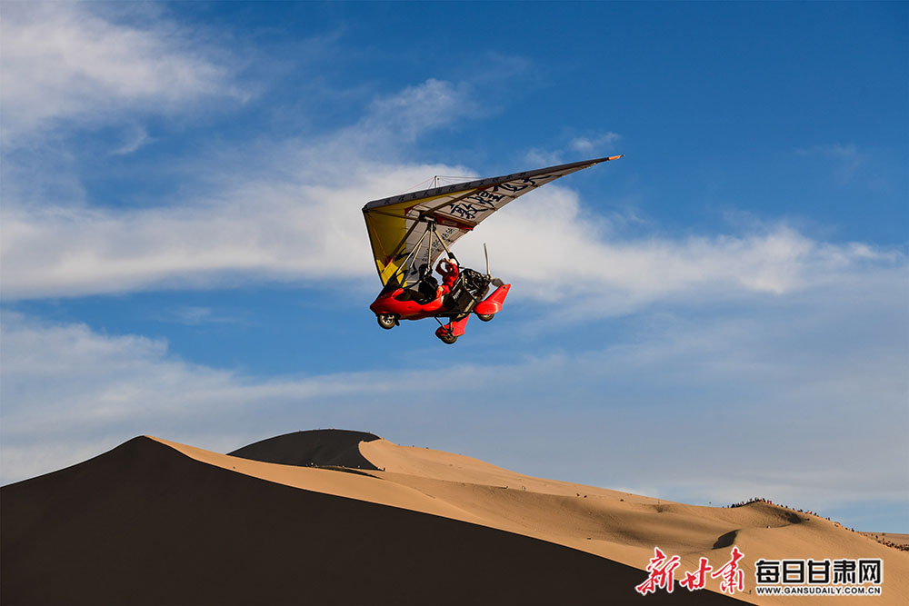 5月6日，游客乘坐滑翔机鸟瞰敦煌大漠风光。