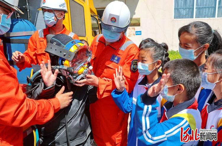 2021年5月11日,北海救助局秦皇岛救助基地救援人员指导海港区东港镇第一小学学生体验穿戴管供潜水设备。